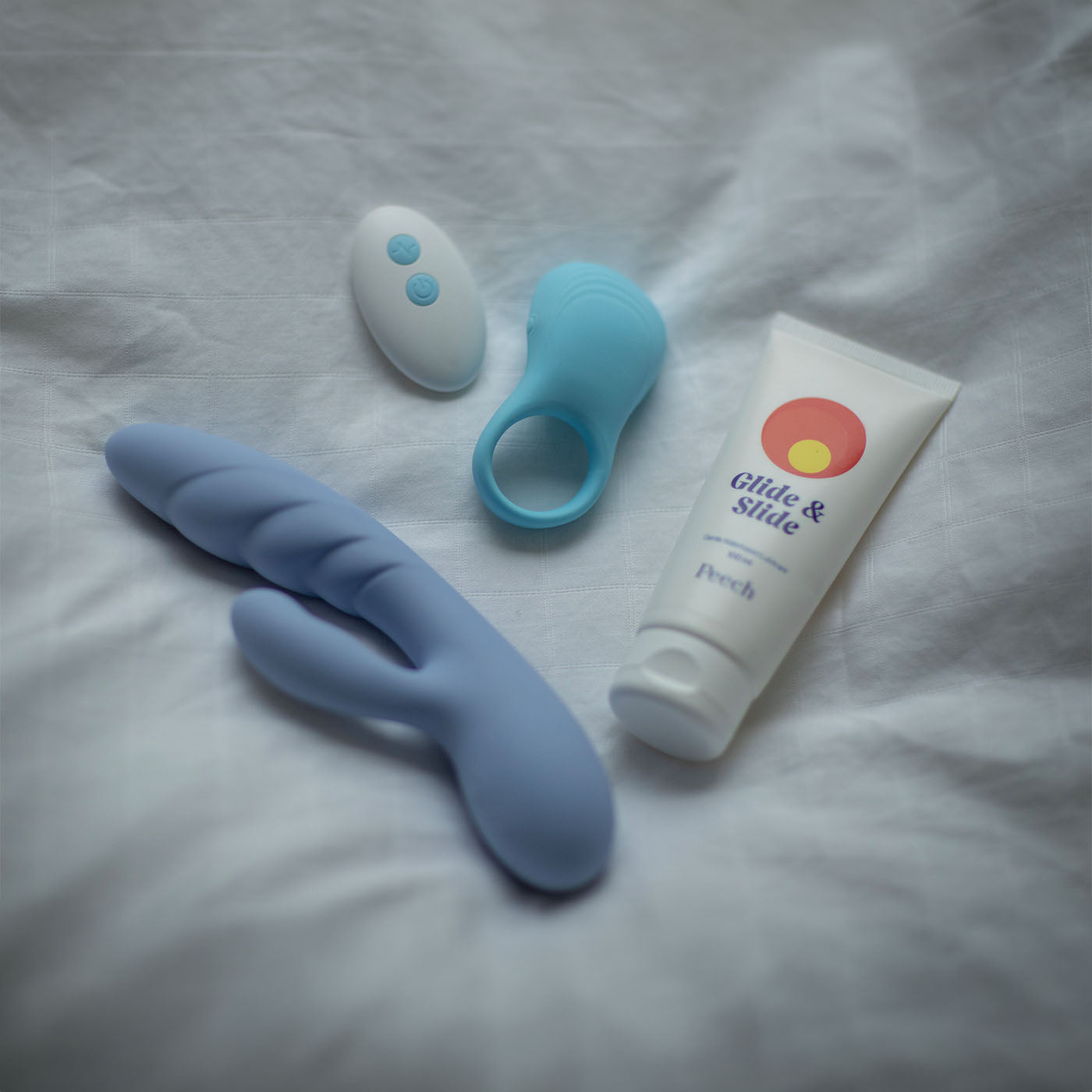 hare rabbit vibrator, power loop vibrerende penisring og vandbaseret glidecreme glide and slide på hvid seng