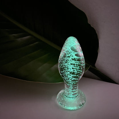 Selvlysende buttplug i glas set fra en anden vinkel
